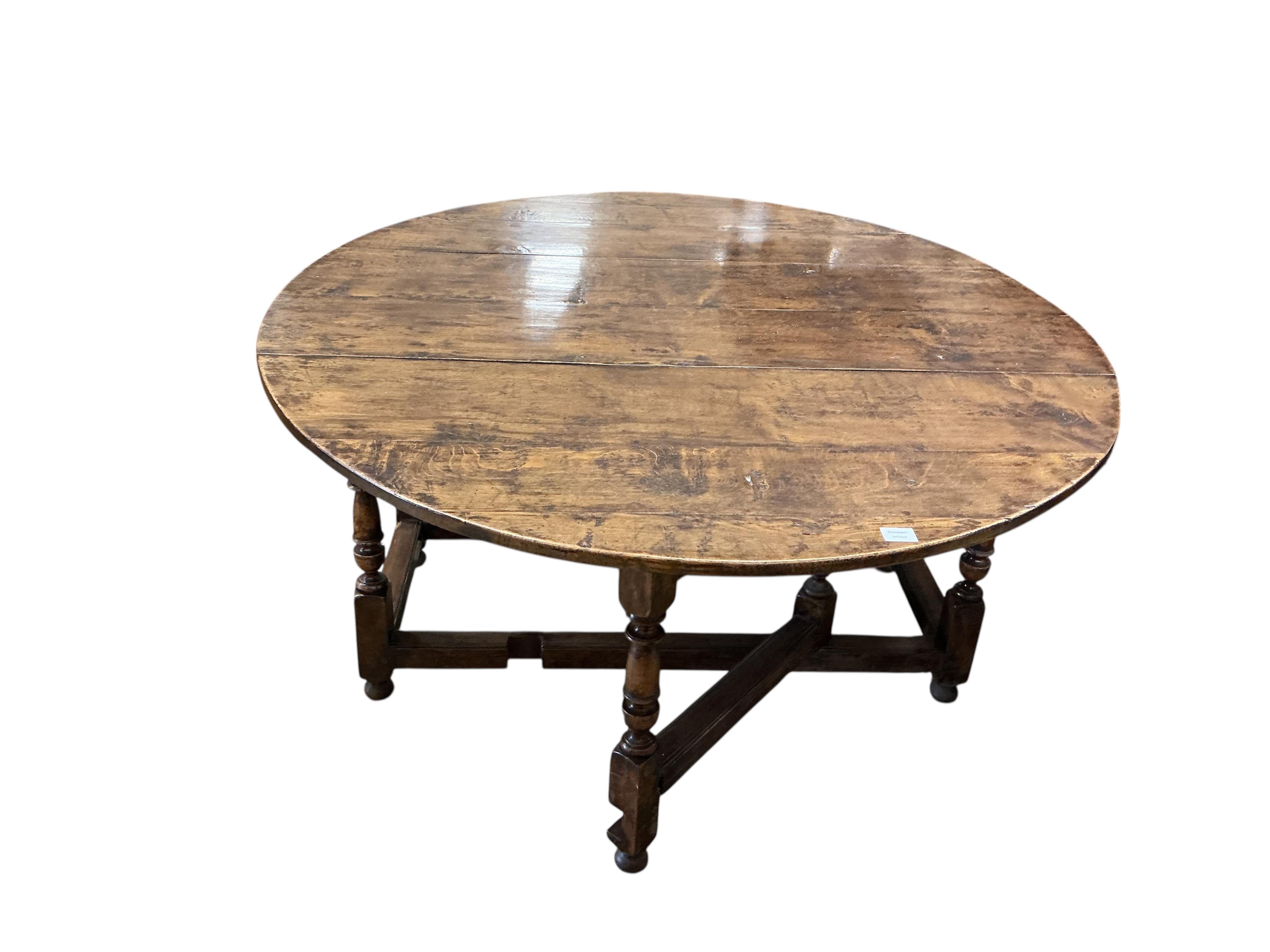 An early 17th century style oak gateleg dining table incorporating earlier elements, width 151cm, depth 62cm, height 75cm